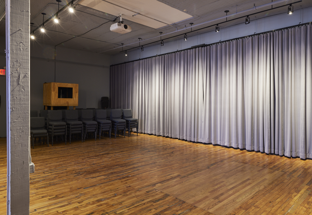 03 Casa Kino Event Space with Open Floor Plan, Hanging Curtain, and Projector