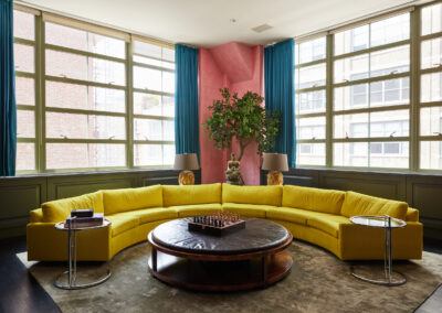 Casa Maxima 11 Sitting Room with Large Yellow Circular Couch and Large Windows for Natural Light