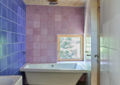 16 Casa Cometa Space Rental Interior Bathroom vertical with blue tiles and pink tiles and mass timber spruce ceiling and bathtub